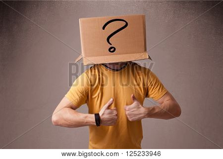 Young man standing and gesturing with a cardboard box on his head with question mark