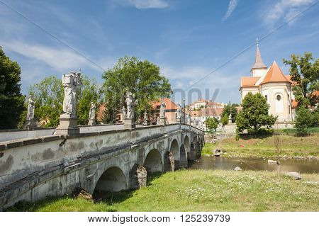 Baroque bridge with statue and a church in Namest nad Oslavou, Czech Republic