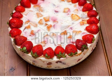 Cake with strawberries gelly yogurt and cherries shot from above over wooden table
** Note: Shallow depth of field