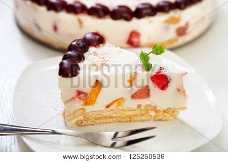 Cake with cherris gelly yogurt and fruits. Isolated on white background. One piece in a white plate. Horizonta; shot
** Note: Shallow depth of field