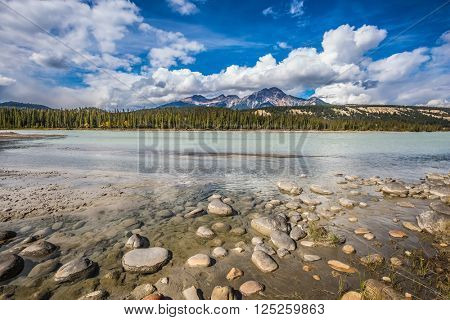  Beneaped Medicine Lake in the fall. Evergreen forests and Rocky Mountains of Canada
