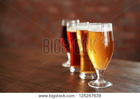 Glasses with different sorts of craft beer on wooden table