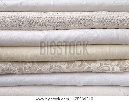 Stack of cool summer white and ivory clothes with different textures
