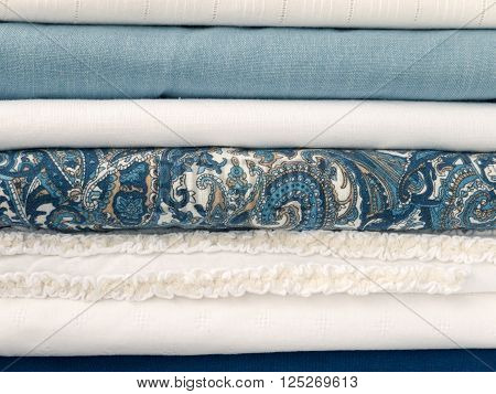 Stack of cool summer white and blue clothes with different textures