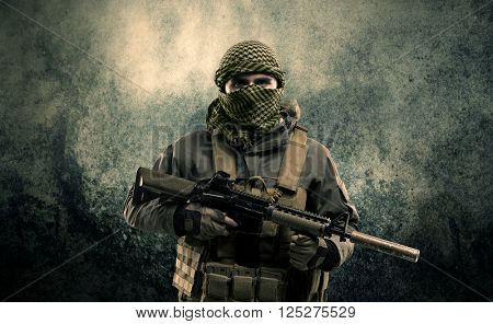 Portrait of a heavily armed masked soldier with grungy background concept