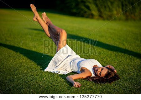 Beaytiful girl lying on green grass