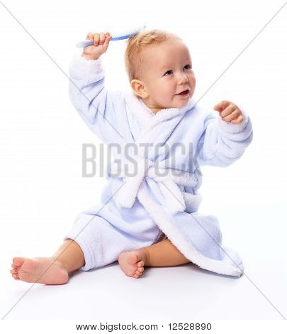 Bambino carino In accappatoio con pettine