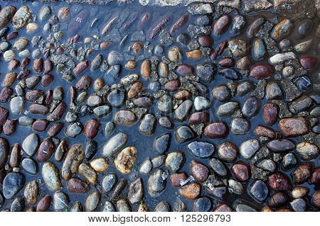 Closeup of gravel pavement covered with water
