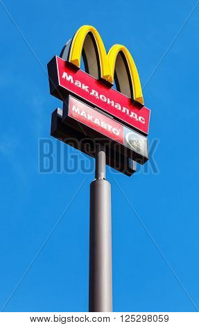 SAMARA RUSSIA - APRIL 10 2016: McDonald's logo on a pole against the blue sky. McDonald's is the world's largest chain of hamburger fast food restaurants