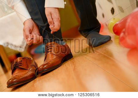 Man tied shoelace to his bown shoes in natural light