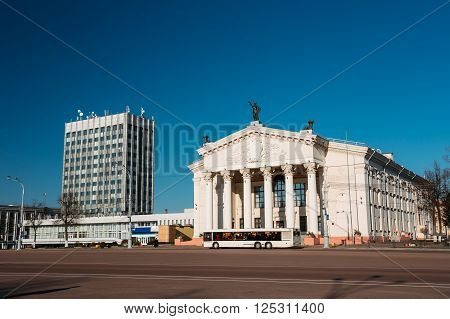 City Bus Moving Along Street Near Building Of Gomel Regional Drama Theatre On The Lenin Square In Gomel, Belarus.