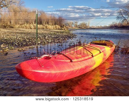 kayak and barbed wire  fence across river - St Vrain Creek below Longmont in Colorado