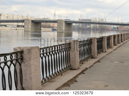 Volodarsky Bridge and fence on the embankment of the Neva River in St.Petersburg at cloud spring day Russia.