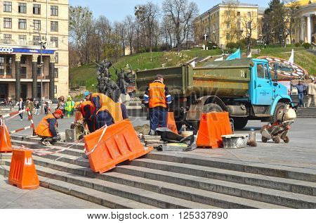 Utility workers in orange vests repair after riot and vandalism 2013-2014. Khreshatik - central street of Kiev.At April 8,2016 in Kiev, Ukraine
