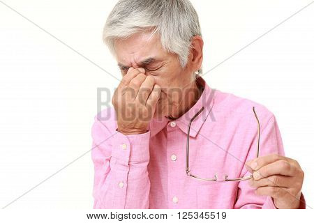 portrait of senior Japanese man suffers from Asthenopia