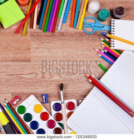 Paints, brushes, colored pencils and album - drawing tools on a desk