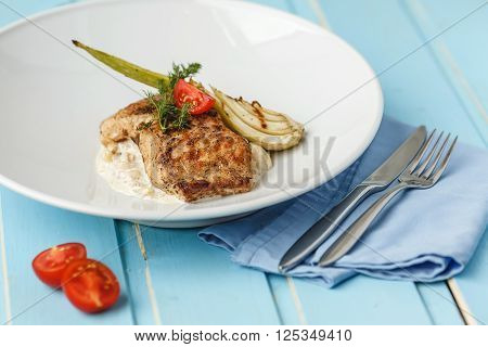 Grilled fish with sause and vegetable on blue wood backgraund