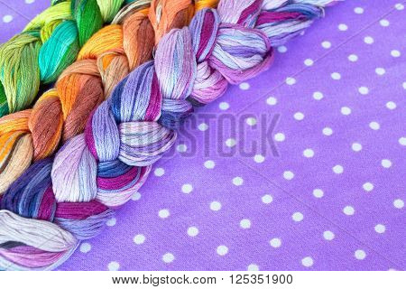 Embroidery threads of different colors on a purple background