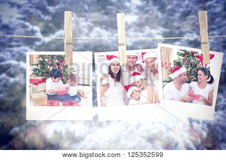 Happy brother and sister looking at Christmas gifts against snow covered trees against sky