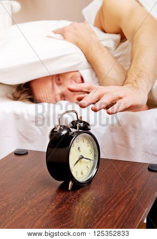 Man trying to sleep, when alarm clock ringing