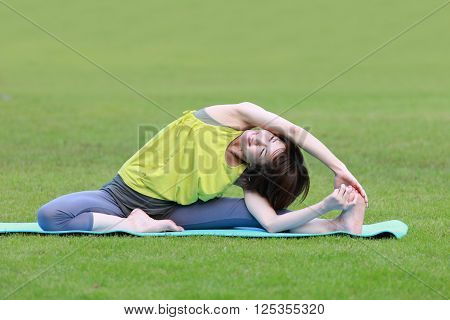portrait of Japanese woman outside doing stretches exercise