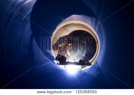 A worker engaged in the pipe welding on the pipeline construction