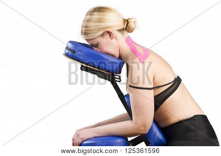 Patient In Massage Chair With Pink Kinesio Tape Over White Background.