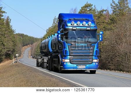 SALO, FINLAND - APRIL 10, 2016: Blue Scania R500 tank truck moves uphill on rural road at spring.