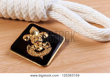 Orderliness White Scout Rope With Vintage Boy Scouts Badge On Wooden Table.