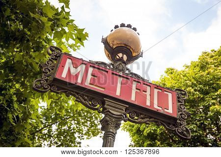Close-up of old sign for metro station in Paris France. From below