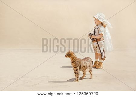 Concept of travel and fascinating adventures. hild in suit of treasures seeker in the desert whit wild cat similar to tiger