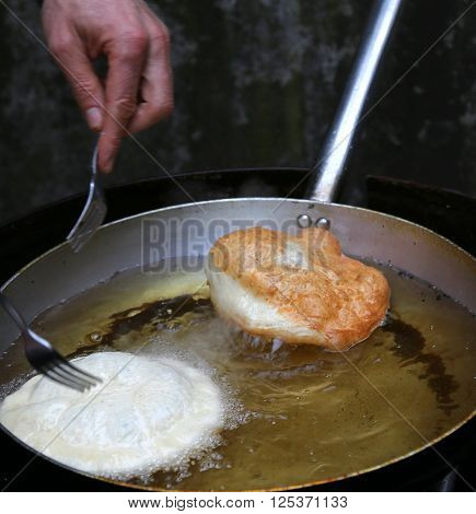 Street Vendor While Cooking The Tasty Fritters Dipped In Boiling Oil