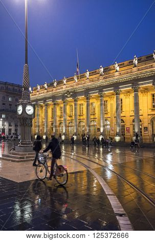 Bordeaux France - March 25 2016. Men in bike rolling in front of Grand Theatre de Bordeaux at night. The theatre is home to the Opera National de Bordeaux and the Ballet National de Bordeaux. Bordeaux Aquitaine. France.
