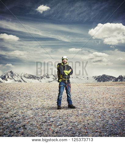 Man wear winter clothes and hard-hat and crossed his hands and stay in the mountains