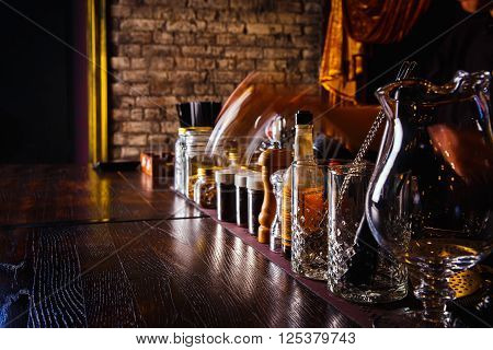 Bartender works with tools on bar at the night club