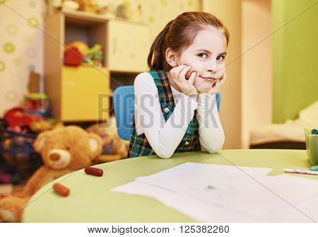 A little girl with a naughty smirk on her face in her playroom