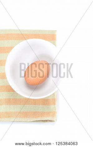 Raw fresh egg in bowl on color napery on white background.