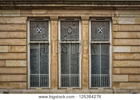 Three windows on an old tenement building in the Scottish city of Glasgow.