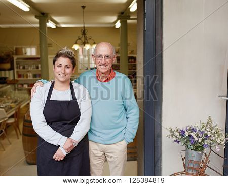 A deli owner and his daughter standing in their shop