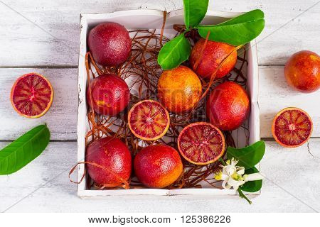Juicy blood oranges whole and half on a white background.
