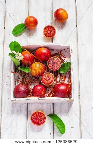 Juicy blood oranges whole and half on a white background.