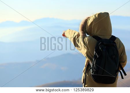 Young Explorer With Winter Jacket And Backpack Indicates The Horizon From Above The Top Of The Mount