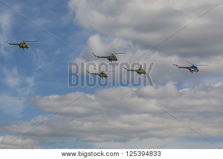 Minsk Belarus-June 21 2014: Team of MI-2 Helicopters Performing Elements in Air In Front of Spectators During Aviation Sport Event Dedicated to the 80th Anniversary of DOSAAF Foundation in Minsk on June 21 2014 in Minsk Republic of Belarus