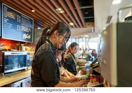 HONG KONG - MARCH 08, 2016: worker at McCafe in the Airport. McCafe is a coffee-house-style food and drink chain, owned by McDonald's.