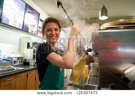 SAINT PETERSBURG, RUSSIA - MARCH 12, 2016: worker at Starbucks Cafe. Starbucks Corporation is an American global coffee company and coffeehouse chain based in Seattle, Washington