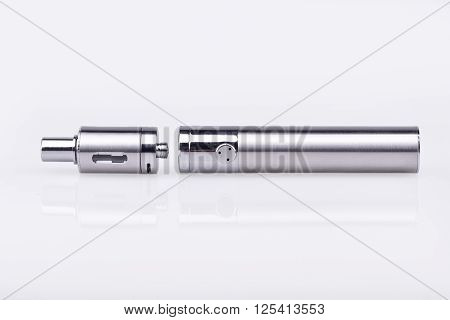 Disassembled e-cigarette atomizer and battery mod on white background
