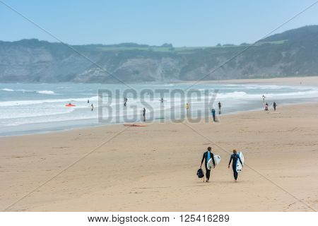 Surfers Walking Together Towards The Ocean