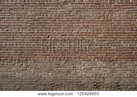 Worn and weathered red brick building wall