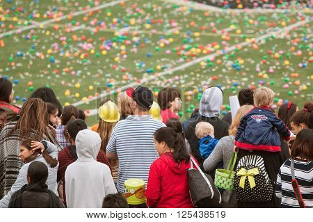 MARIETTA, GA - MARCH 2016: Children and families stand waiting for the start of a massive community Easter egg hunt on a local high school football field in Marietta GA on March 26 2016.