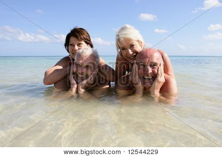 Portret van een groep van lachende senioren badend in de zee